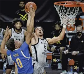  ??  ?? OREGON’S Chris Duarte is fouled by Jaylen Clark on a drive during the second half. Duarte scored 23 points for the Ducks, who took the lead in the Pac-12.