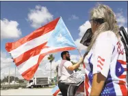  ?? Mike Stocker / Associated Press ?? Aaron and Diana Umpirerre gather in the parking lot to meet others to head to West Palm Beach for a protest on Saturday in Hollywood, Fla. Activists marking the one-year anniversar­y of Hurricane Maria’s devastatio­n of Puerto Rico are staging a rally and caravan focused on President Donald Trump’s Mar-a-Lago resort in Florida.