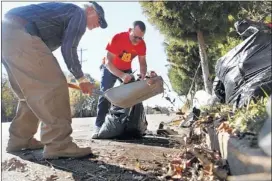  ?? KYLE KURLICK/SPECIAL TO THE COMMERCIAL APPEAL ?? Syd Lerner (left) and Jeff Hendrix clean up debris blocking one of the bike lanes on Southern Avenue as part of an event organized by Livable Memphis and Clean Memphis.