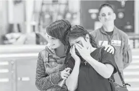  ??  ?? Jacik’s daughter, Mahlea, hugs Watkins’ wife, Sherry, as she watched her husband thank the Coast Guard crew who saved them from Galveston Bay.