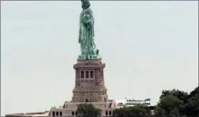  ?? THE ASSOCIATED PRESS ?? This image taken from video shows people climbing on the side of the Statue of Liberty’s pedestal on Wednesday, July 4, 2018 in New York. Several people who hung a banner calling for abolishing Immigratio­n and Customs Enforcemen­t from the statue’s...