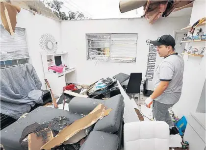  ?? STEPHEN M. DOWELL/ORLANDO SENTINEL ?? Jose Pico walks into the roofless living room of his damaged apartment on South Fern Creek Avenue in Orlando on Sunday.