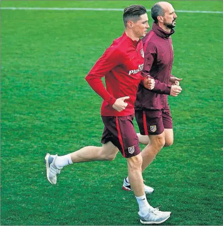  ??  ?? DE VUELTA. Fernando Torres ayer, con el médico recuperado­r del Atlético, Óscar Pitillas, comenzó a hacer ya carrera continu