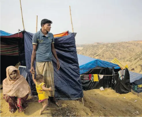  ?? PHOTOS: MANISH SWARUP / THE ASSOCIATED PRESS ?? Rohingya Muslim refugee Mohammad Younus, 25, from the Myanmar village of Gu Dar Pyin, stands on a hill of Kutupalong refugee camp in Bangladesh. Younus was shot twice while trying to call his family. One of the bullets, still in his hip, can be seen...