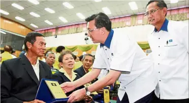  ??  ?? Showing gratitude: Liow presenting a long-serving award to party veteran Chan Hai Men while Pahang MCA chairman Datuk Hoh Khai Mun (right) looks on.