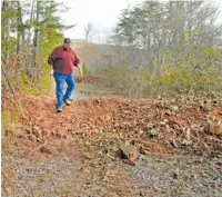  ?? STAFF FILE PHOTO ?? In 2014, Jim Sirmans, with the Coker Creek Heritage Group, scales one of the 35 berms mistakenly built by the U.S. Forestry Service.