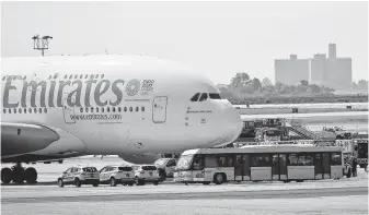  ?? Bebeto Matthews / Associated Press ?? Emergency response crews gather outside a plane at New York’s Kennedy Airport amid reports of ill passengers aboard a flight from Dubai on Wednesday.