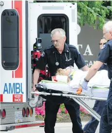  ?? DON SIPOS/FILES ?? Paramedics load a victim into an ambulance in Kelowna on Aug. 14, 2011 after a shooting outside the Delta Grand Hotel. Jonathan Bacon was shot dead. Five others were taken to Kelowna Hospital.