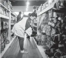  ??  ?? Jersey Day organizer Jennifer Pinch works Wednesday at the petsupply store she owns in Langley.