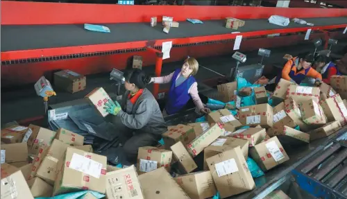  ?? PHOTOS BY ZHU XINGXIN / CHINA DAILY ?? Workers sort parcels at a warehouse in Tianjin, North China.