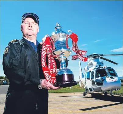  ?? Picture: SNS. ?? Pilot David Blane poised to deliver the silverware from Cumbernaul­d Airport.