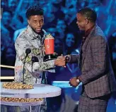  ?? [PHOTO BY MATT SAYLES, INVISION/AP] ?? Chadwick Boseman, left, gives his best hero award for his role in “Black Panther” to James Shaw Jr., who is credited with saving lives during a shooting at a Waffle House in Antioch, Tennessee.