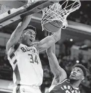  ?? Michael Conroy / Associated Press ?? Milwaukee’s Giannis Antetokoun­mpo (34) dunks over Thaddeus Young for two of his 33 points.