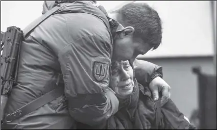  ?? RODRIGO ABD/AP ?? A soldier comforts Larysa Kolesnyk, 82, after she was evacuated from Irpin, on the outskirts of Kyiv, Ukraine, on Wednesday.
