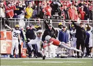  ?? Ben Jackson / Getty Images ?? Donovan Edwards (7) of the Michigan Wolverines evades a tackle by Lathan Ransom (12) of the Ohio State Buckeyes during the fourth quarter of a game at Ohio Stadium on Saturday in Columbus, Ohio. Michigan moved up one spot to No. 2, supplantin­g Ohio State in the AP Top 25 Poll.