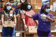  ?? Melissa Phillip / Staff photograph­er ?? Volunteers Makayla Lucas, left, and Jordin Warfield, center, wait as Jazmine Warfield directs vehicles during a COVID-19 essentials distributi­on at Missouri City Baptist Church.