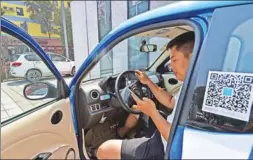  ?? CAO YANG / XINHUA ?? A driver sits behind the wheel of an electric car he has rented from a car service in Taiyuan, Shanxi province, in July.