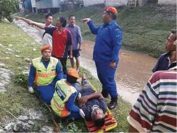  ??  ?? ANGGOTA APM memberi rawatan kepada mangsa yang parah akibat terjatuh pokok Serai Kayu di Jalan Melati 10, Gombak Setia.