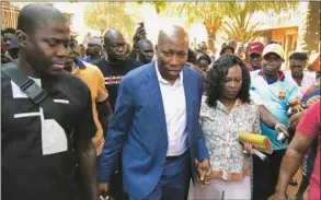  ??  ?? Guinea-Bissau’s former Prime Minister Domingos Simoes Pereira walks with his wife after voting in the second round of the presidenti­al election at a polling station in Bissau, yesterday.