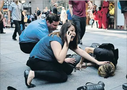  ?? JEWEL SAMAD / AFP ?? Dos personas atienden a uno de los heridos arrollados por un vehículo en Times Square