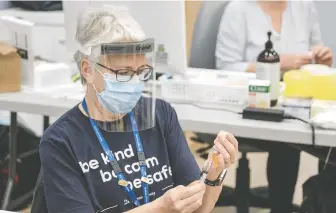  ?? POSTMEDIA/FILES ?? An Island Health worker prepares a vaccine dose. B.C. health officials should have been able to estimate the amount of surplus, says Dr. Brian Conway, Vancouver Infectious Diseases Centre medical director.