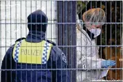 ?? DPA VIA AP ?? Investigat­ors and forensic experts stand outside a Jehovah’s Witness building in Hamburg, Germany, Friday where multiple people were killed and wounded.