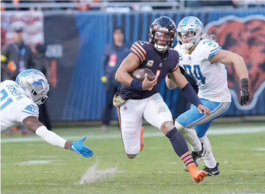  ?? CHARLES REX ARBOGAST/AP ?? Justin Fields, who has come alive in an offense that now plays to his strengths, has Lions defenders scrambling during his 67-yard TD run last week.