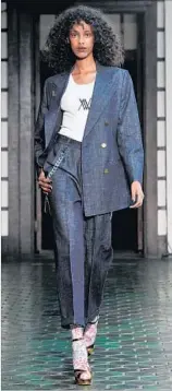  ?? John Sciulli Getty Images for Wolk Morais ?? A SHARP, double-breasted denim suit, accessoriz­ed with a pocket chain, hits the runway.