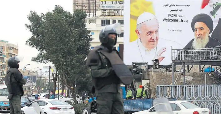  ?? REUTERS ?? Bienvenida. Soldados custodian en Bagdad bajo un enorme afiche que muestra al papa Francisco junto al anciano líder de los shiitas iraquíes, el Gran Ayatollah Ali Sistani.