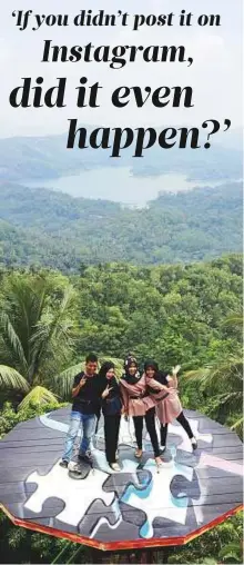  ?? Bloomberg ?? Visitors pose for photograph­s while standing on a platform at the Pule Payung Tourism Hill in Yogyakarta, Indonesia.