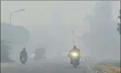  ?? HT FILE ?? Motorists drive with their vehicles’ headlights on as thick smog engulfs Ludhiana.