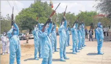  ?? PTI ?? Madhya Pradesh Police contingent­s, in PPE kits, pay tributes to slain Sub-inspector Mohan Singh Patel, who succumbed to Covid19, in Bhopal on Wednesday.