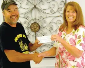  ??  ?? Lincoln Area Chamber board member John Blosser gave Tina Batlle at the Lincoln Senior Center last week a check for $768.73. The donation was money the Chamber earned from a successful car show, the Chicken Rod Nationals, held in June.