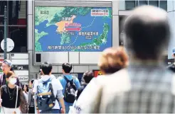  ??  ?? People walk near a screen which reports North Korea’s missile launch, in Osaka, western Japan Monday, May 29. North Korea fired a short-range ballistic missile that landed in Japan’s maritime economic zone yesterday, officials said, in the latest in a...