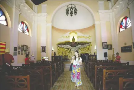  ?? Ismael Francisco/The Associated Press ?? A tourist walks through a Spanish-style church at the Hermitage of Monserrate in Matanzas, Cuba.