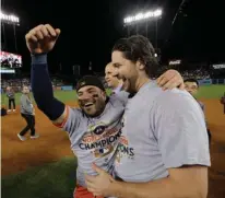  ?? Associated Press ?? Houston Astros' Jose Altuve and Jake Marisnick celebrate after Game 7 of baseball's World Series against the Los Angeles Dodgers Wednesday in Los Angeles. The Astros won, 5-1, to claim the series, 4-3.