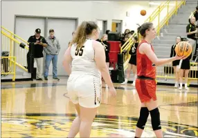  ?? MARK HUMPHREY ENTERPRISE-LEADER ?? Picture of sportsmans­hip. Farmington junior Jenna Lawrence hands the ball to a referee (not pictured) with time expiring and the scoreboard displaying the final score, 63-49, of the Lady Cardinals’ road win at rival Prairie Grove on Tuesday, Jan. 4.