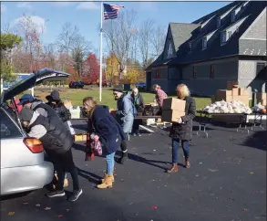  ?? ?? Volunteers put food in a car at St. Andrew's Church on Friday morning.