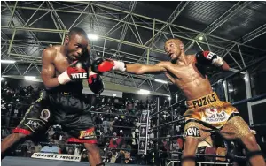  ?? / MICHAEL PINYANA ?? Azinga Fuzile, right, lashes at Rofhiwa Maemu during their SA featherwei­ght bout in July.