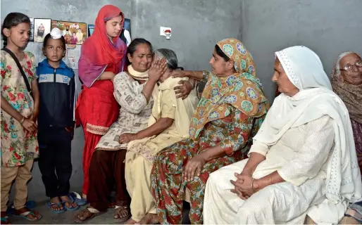  ?? AP ?? Relatives of Gurcharan Singh, one of the 39 workers whose bodies were found buried near Mosul, mourn in his hometown in Jalal Usma village in Punjab on Tuesday. —