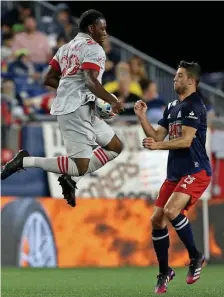  ?? MATT sTONE / HErAld sTAff filE ?? HEADS-UP: Toronto’s Ayo Akinola goes for the ball as New England’s Matt Polster moves in during the first half at Gillette Stadium on June 8.