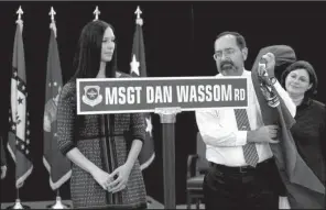  ?? Arkansas Democrat-Gazette/RICK McFARLAND ?? Dan Wassom Sr. and Suzanne Wassom, widow of Master Sgt. Dan “Bud” Wassom II, Saturday unveil a street sign for a 1-mile portion of the main road at Little Rock Air Force Base to honor the Arkansas Air National Guard member who died April 27 while...
