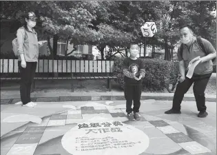  ?? REN CHAO / XINHUA ?? A garbage-sorting game is played at a residentia­l area in Beijing’s Haidian district in May.