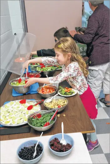  ?? SUBMITTED ?? Grace Walsh, a primary student and Berwick Elementary School, tries out the new salad bar at the school.