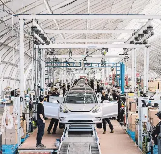  ?? JUSTIN KANEPS NYT ?? Workers on the Tesla Model 3 assembly line at Tesla’s factory in Fremont, Calif., in June. Tesla lost US$742.7 million in the second quarter, and has lost $1.5 billion in the first six months of 2018.