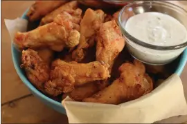  ?? MATTHEW MEAD — THE ASSOCIATED PRESS FILE ?? Party chicken wings with cilantro sour cream dip and honey sriracha are displayed in
..
Concord, N.H., on Nov. 16, 2015. Preparing and keeping foods at the right temperatur­e, avoiding cross contaminat­ion — no double dipping! — and being mindful about leaving out perishable snacks like chicken wings, meatballs and veggie platters are all keys to avoiding illness at your Super Bowl party, health experts said.