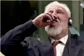  ??  ?? This videograb taken from live footage of the internatio­nal criminal court, shows Croatian former general Slobodan Praljak drinking poison, during his judgment at the UN war crimes court to protest the upholding of a 20- year jail term. —