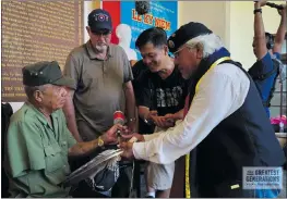  ??  ?? Photos by John Riedy, TGGF (Above) Our Native American soldier, Dalton Tom, presents gifts to a former Viet Cong captain who fought against us on June 19th, 1967. (Below) 21 combat veterans and two former Viet Cong at our memorial service honoring all...