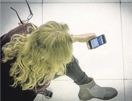 ??  ?? Una mujer revisa en su teléfono su actividad en las redes sociales.