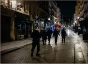  ?? Ap-lewis Joly ?? Police patrol in the streets as the curfew starts in Paris, Saturday. French restaurant­s, cinemas and theaters are trying to figure out how to survive a new curfew aimed at stemming the flow of record new coronaviru­s infections. The monthlong curfew came into effect Friday at midnight, and France is deploying 12,000 extra police to enforce it.